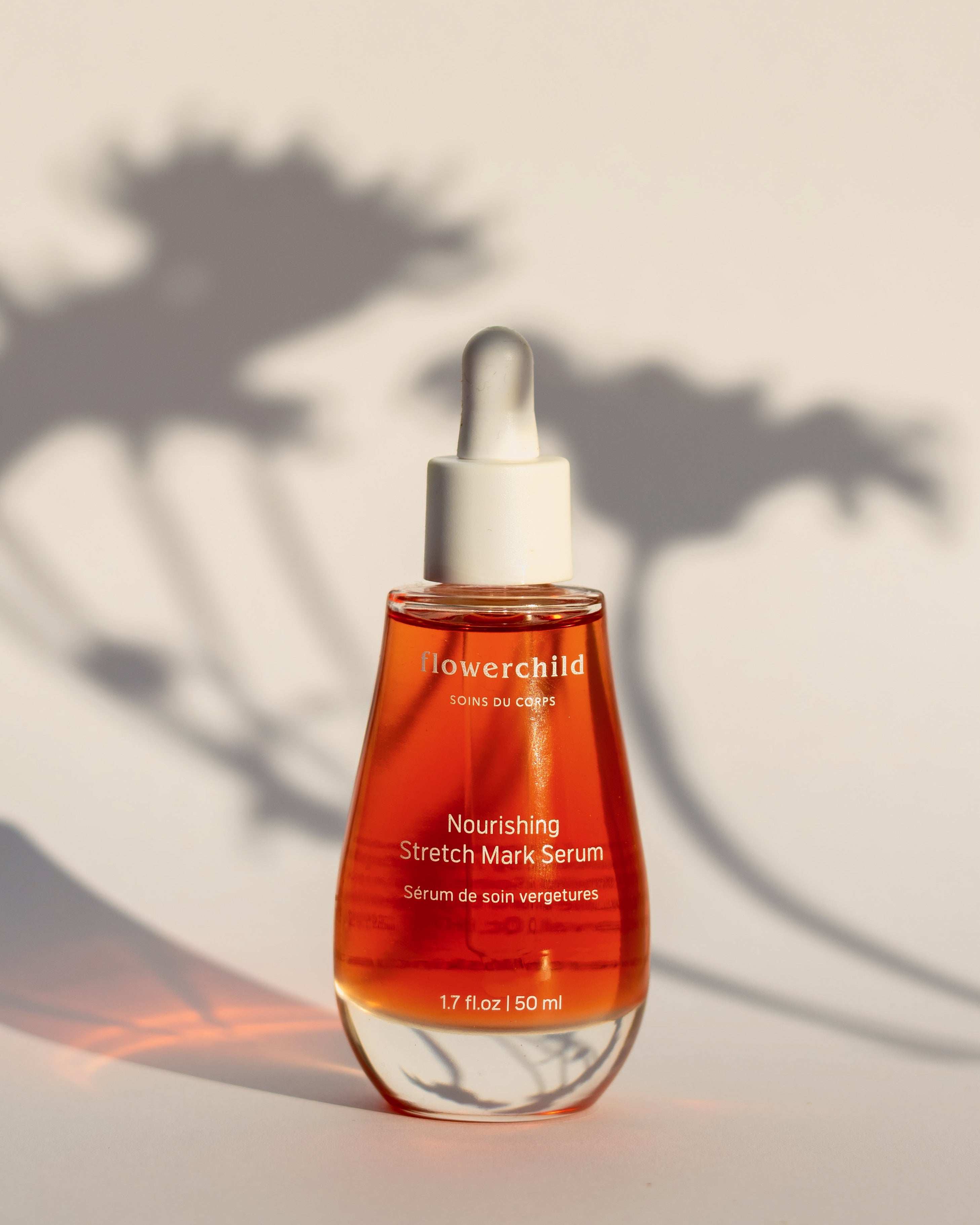 Flacon de sérum de soin vergetures Flowerchild, formule légère et hydratante au camélia, jojoba et argan, naturel pour la grossesse.